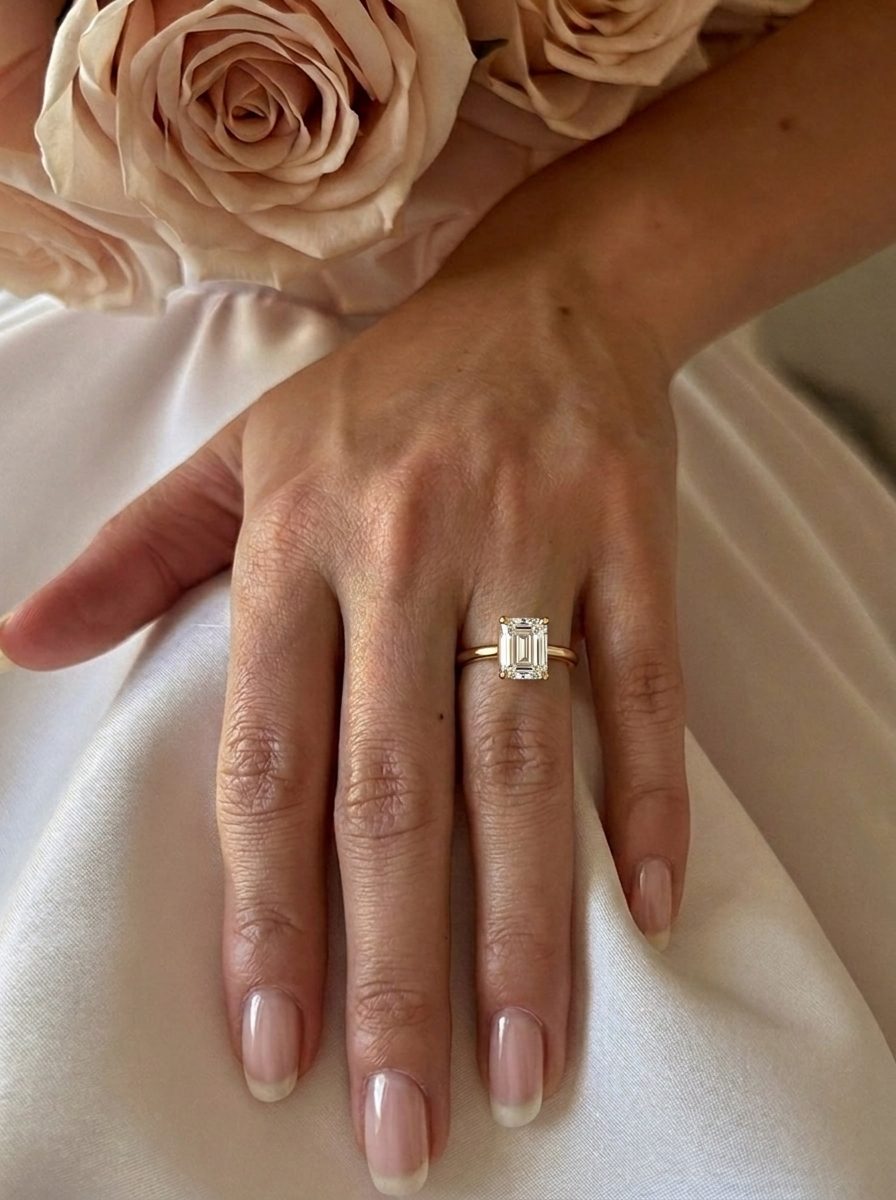 'Delta' Emerald Cut Lab Grown Engagement Ring on the hand, yellow gold