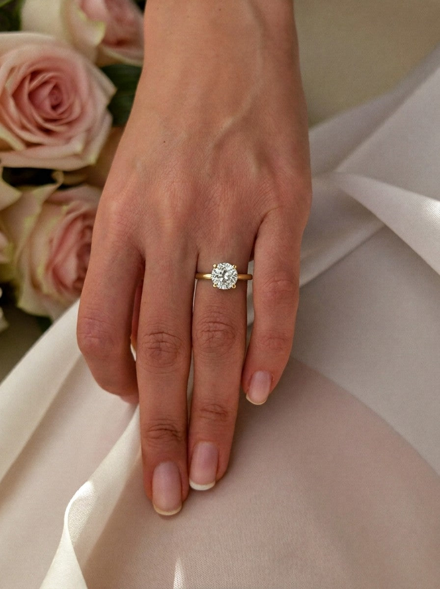 'Nicole' Round Brilliant Cut Engagement Ring on the hand, yellow gold
